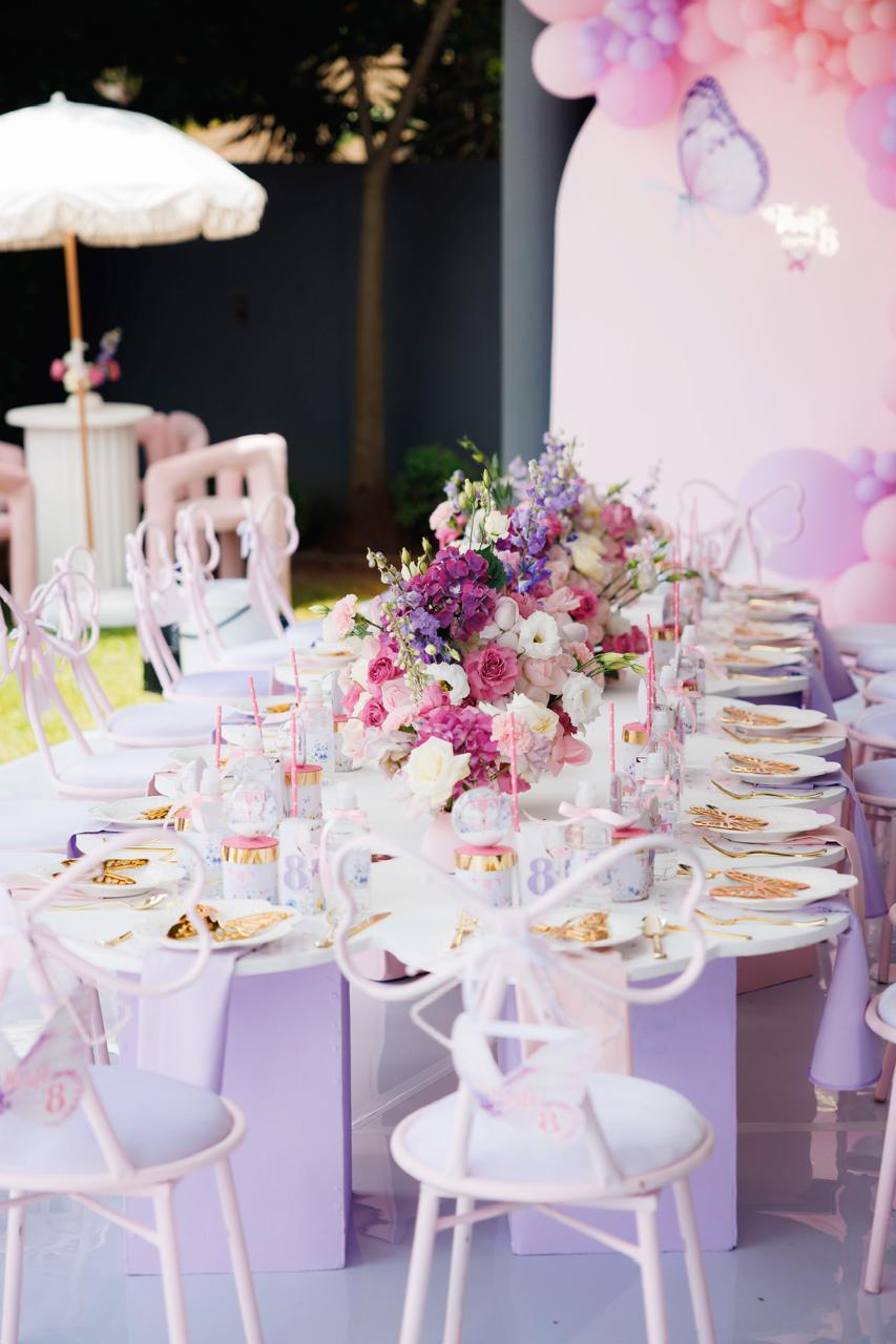 Pink butterfly themed children's table setting with florals