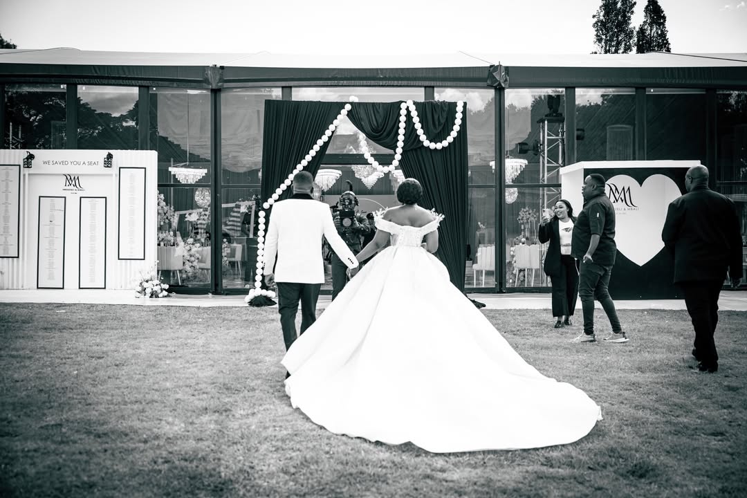 Black and white portrait of bride and groom entering reception