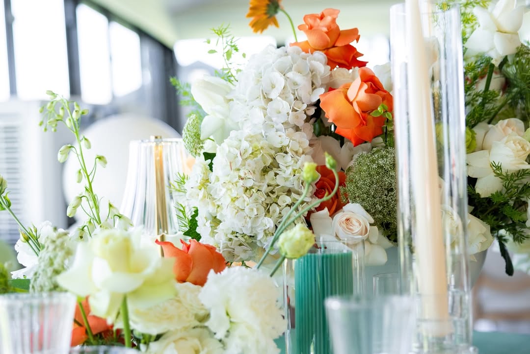 Lush centerpiece of white hydrangea and orange roses