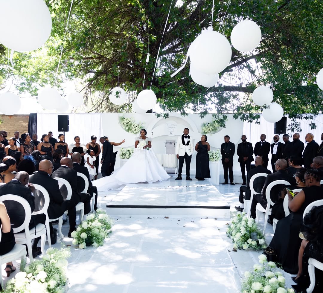 Outdoor luxury wedding ceremony with hanging white orbs and floral aisle